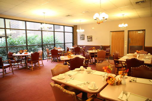 A spacious dining area filled with tables and chairs, offering a cozy atmosphere with ample natural light.
