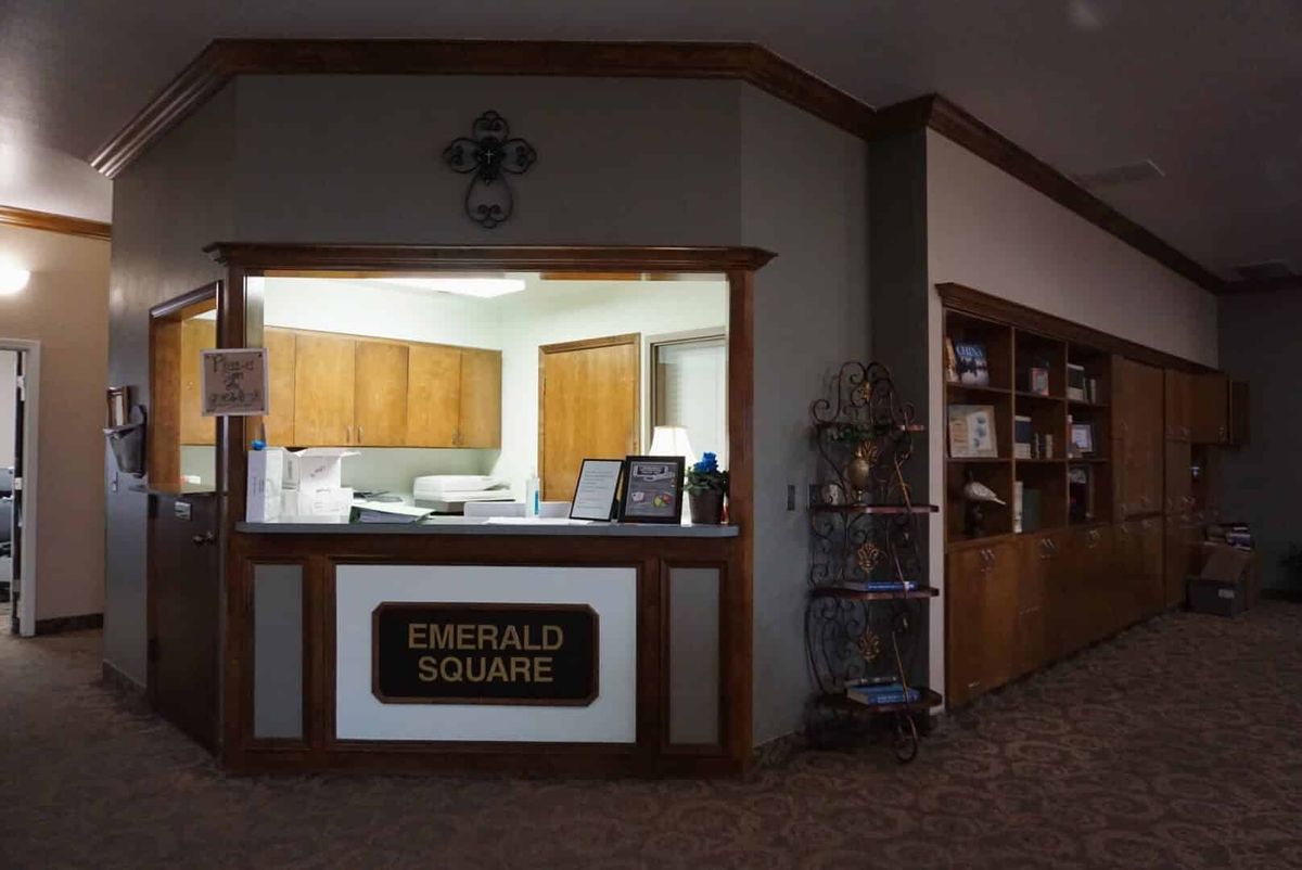 A reception desk at Emerald Square with a visible office area behind it.