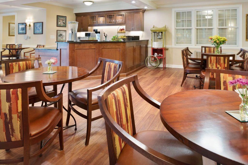 A cozy dining space with wooden tables and chairs, adjacent to a kitchen counter.