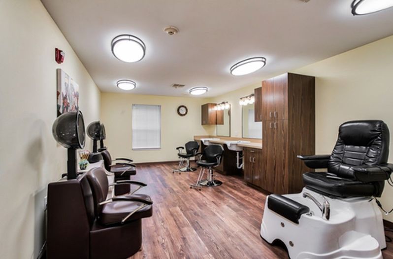 A modern barbershop interior with stylish chairs and large mirrors.