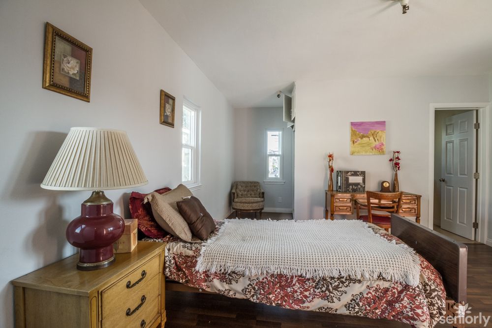 A cozy bedroom with a neatly made bed and decorative elements.