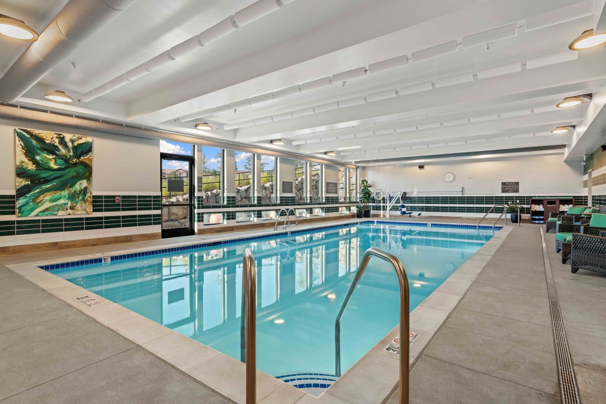 An indoor swimming pool with ample natural light and modern design.