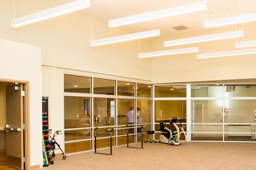 A modern office space featuring glass walls and contemporary lighting.
