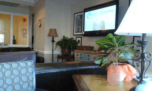 A cozy living room scene featuring a television, a lamp, and indoor plants.