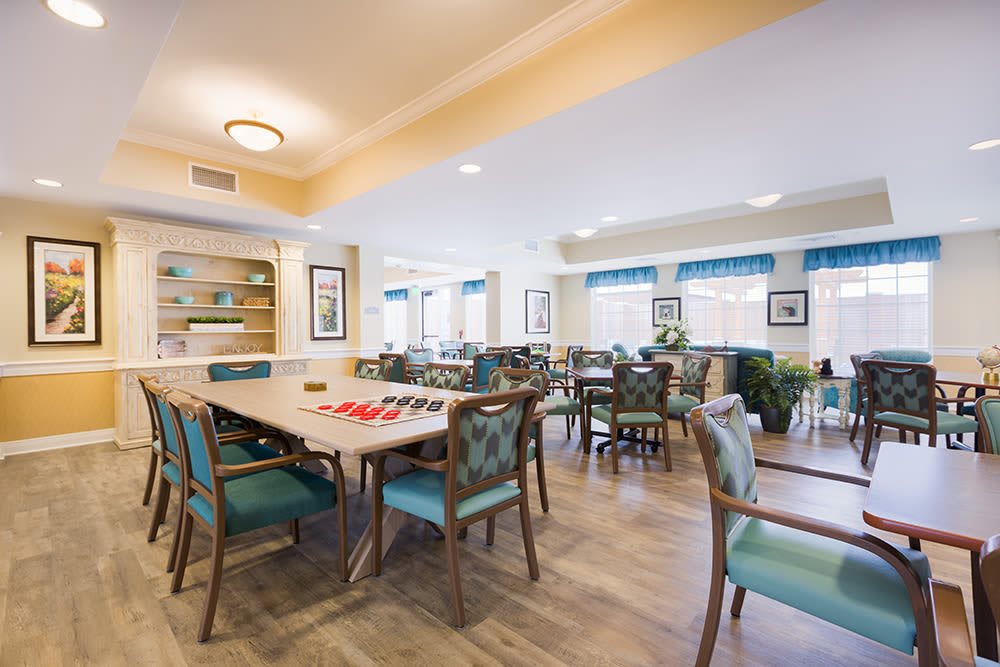 A spacious and well-lit dining area with multiple tables and chairs, suitable for social gatherings.