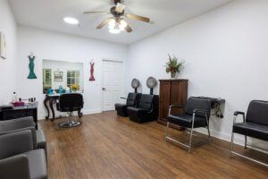 Interior of a hair salon with chairs, hair dryers, and wooden flooring.