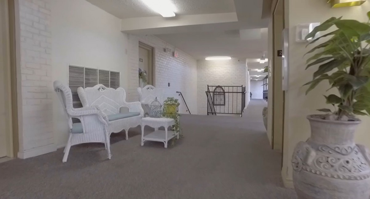 A white hallway with seating and a small table.