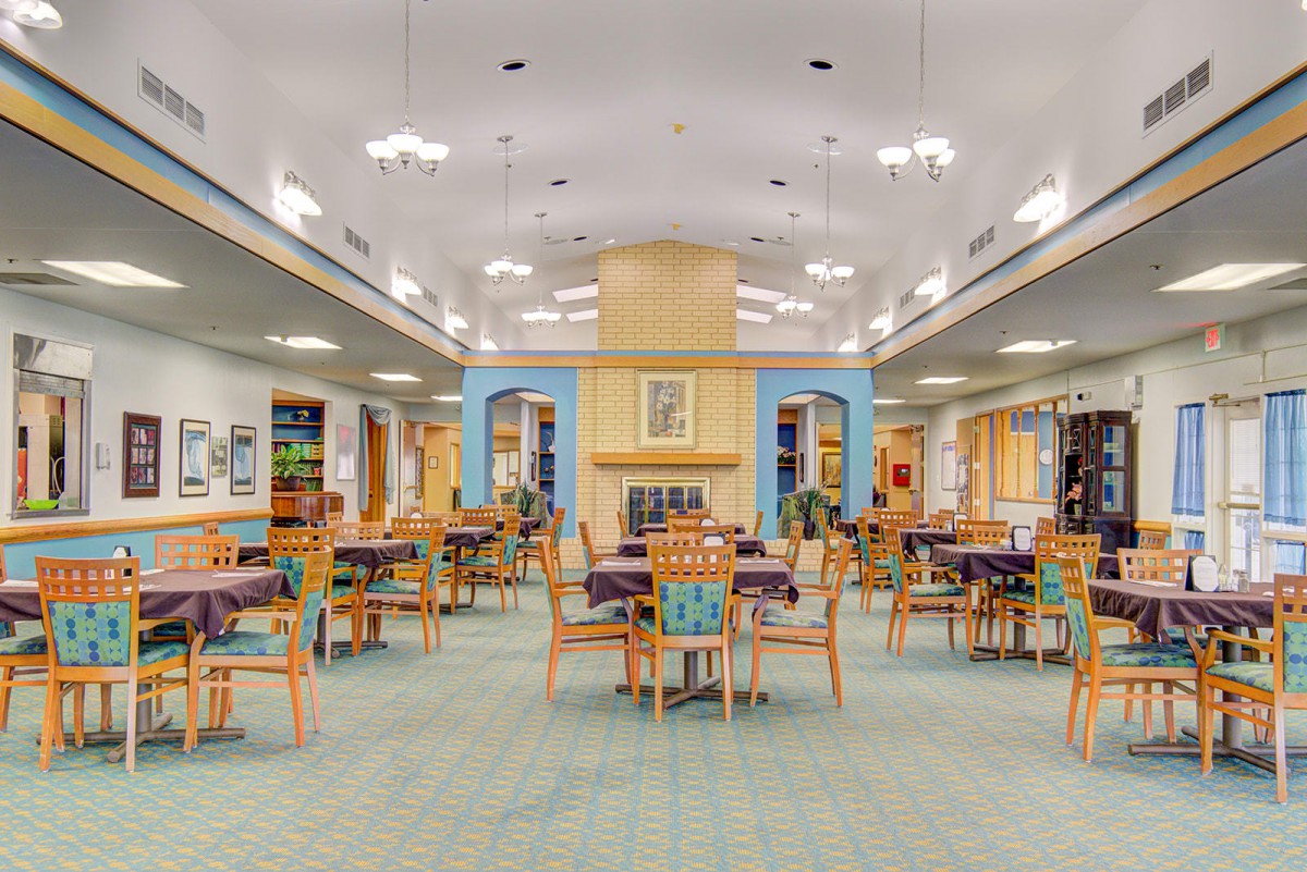 A spacious dining area with neatly arranged tables and chairs, featuring bright lighting and a cozy atmosphere.