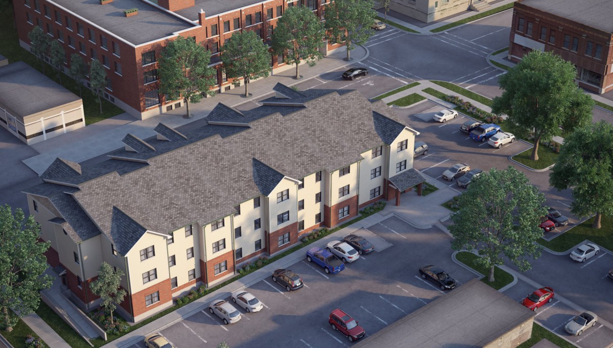 Aerial view of a residential building with a parking lot and surrounding streets.