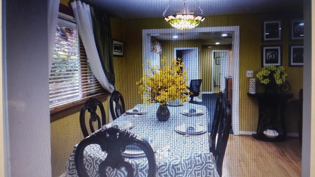A cozy dining room with a patterned tablecloth, floral centerpiece, and decorative lighting.