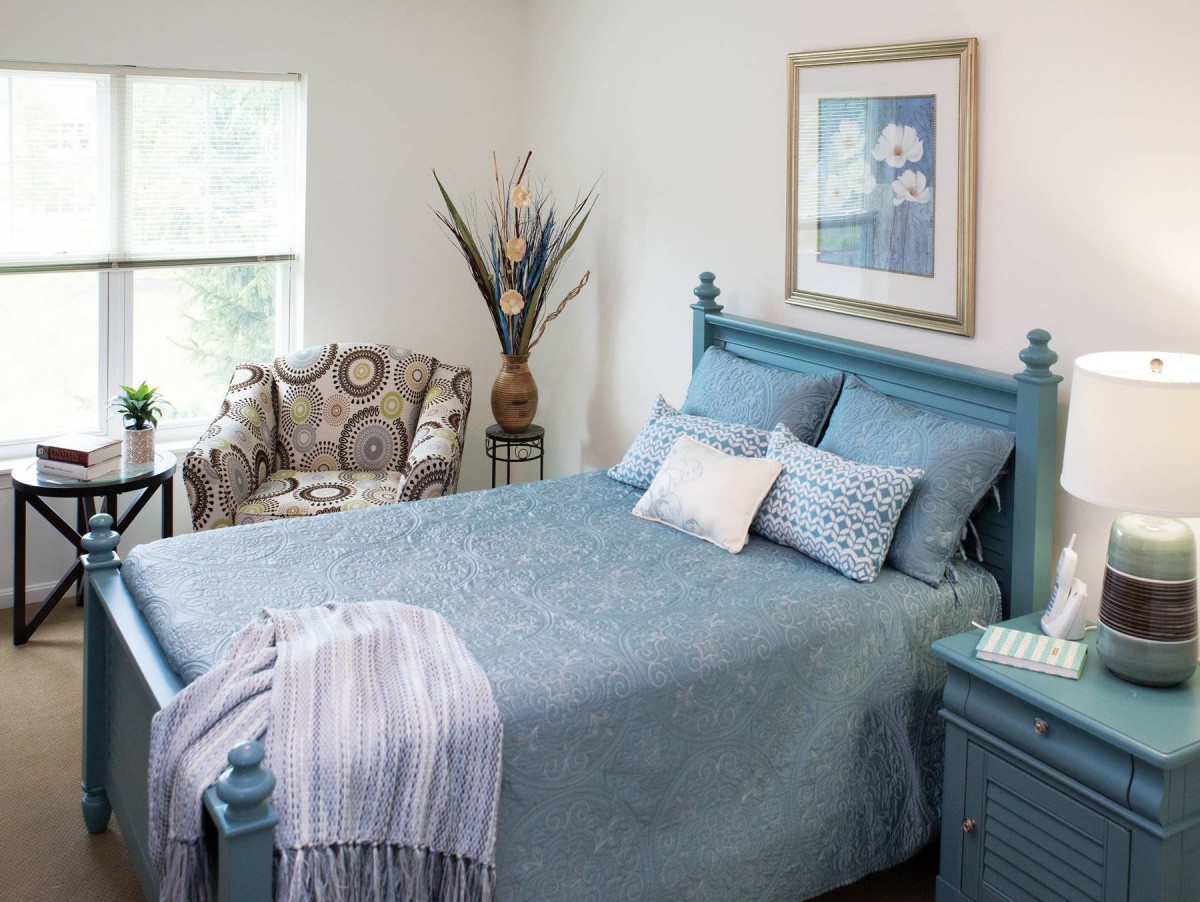 A cozy bedroom with blue bedding and elegant decor.
