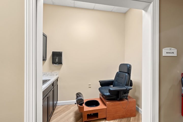 A cozy room featuring a pedicure chair and foot spa setup, designed for relaxation and comfort.