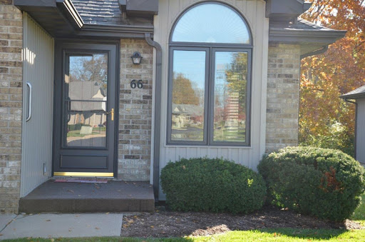 A well-maintained residential exterior featuring a decorative window and lush landscaping.