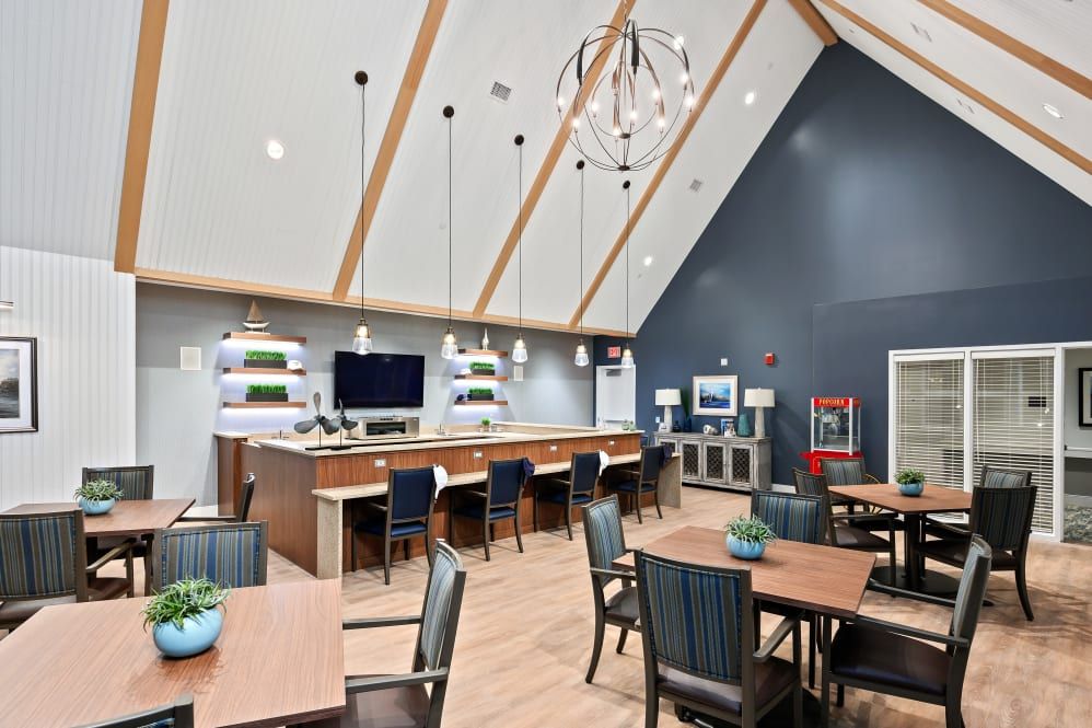 A modern dining and lounge area with vaulted ceilings, pendant lighting, and bar seating.