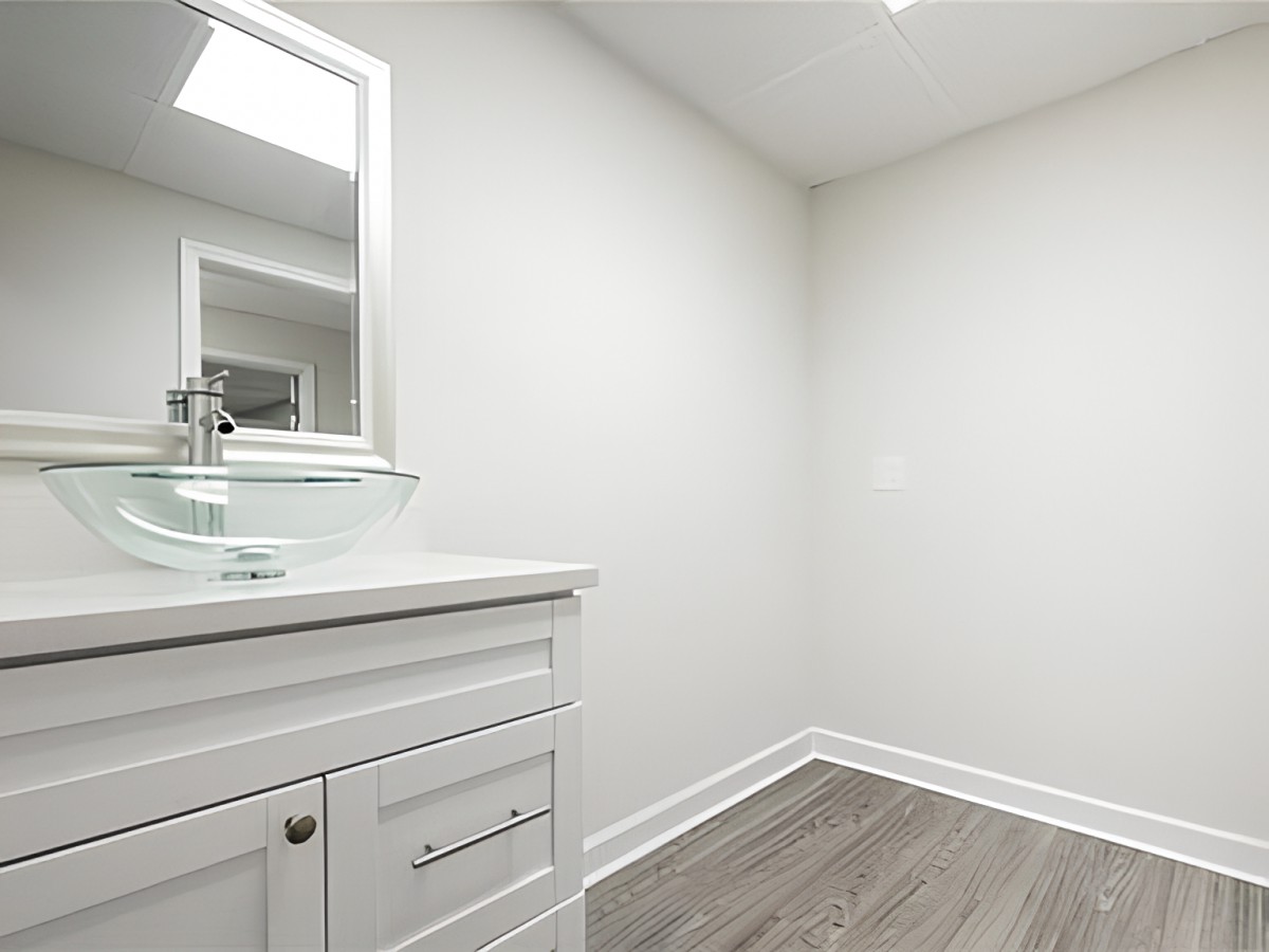 A minimalist bathroom with modern fixtures and light-colored flooring.