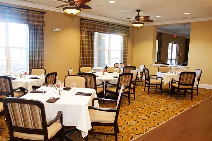 A well-arranged dining room with neatly set tables and comfortable chairs.