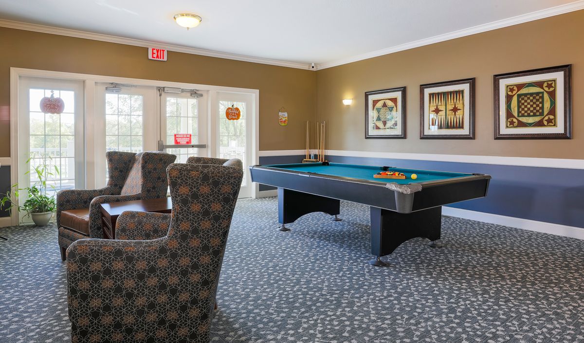 A cozy billiard room featuring a pool table and comfortable seating.
