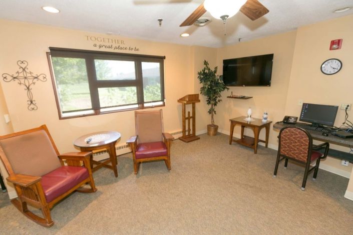 A cozy room with seating, a TV, and a large window.