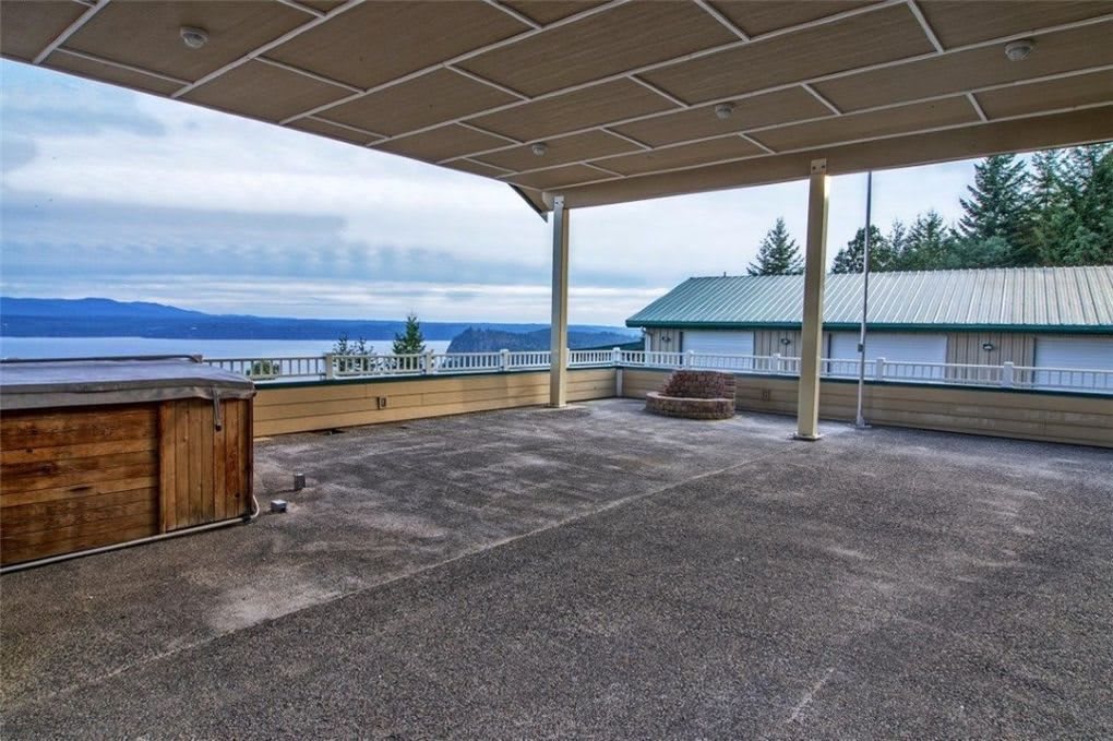 A spacious patio with a scenic view of the water and surrounding greenery.