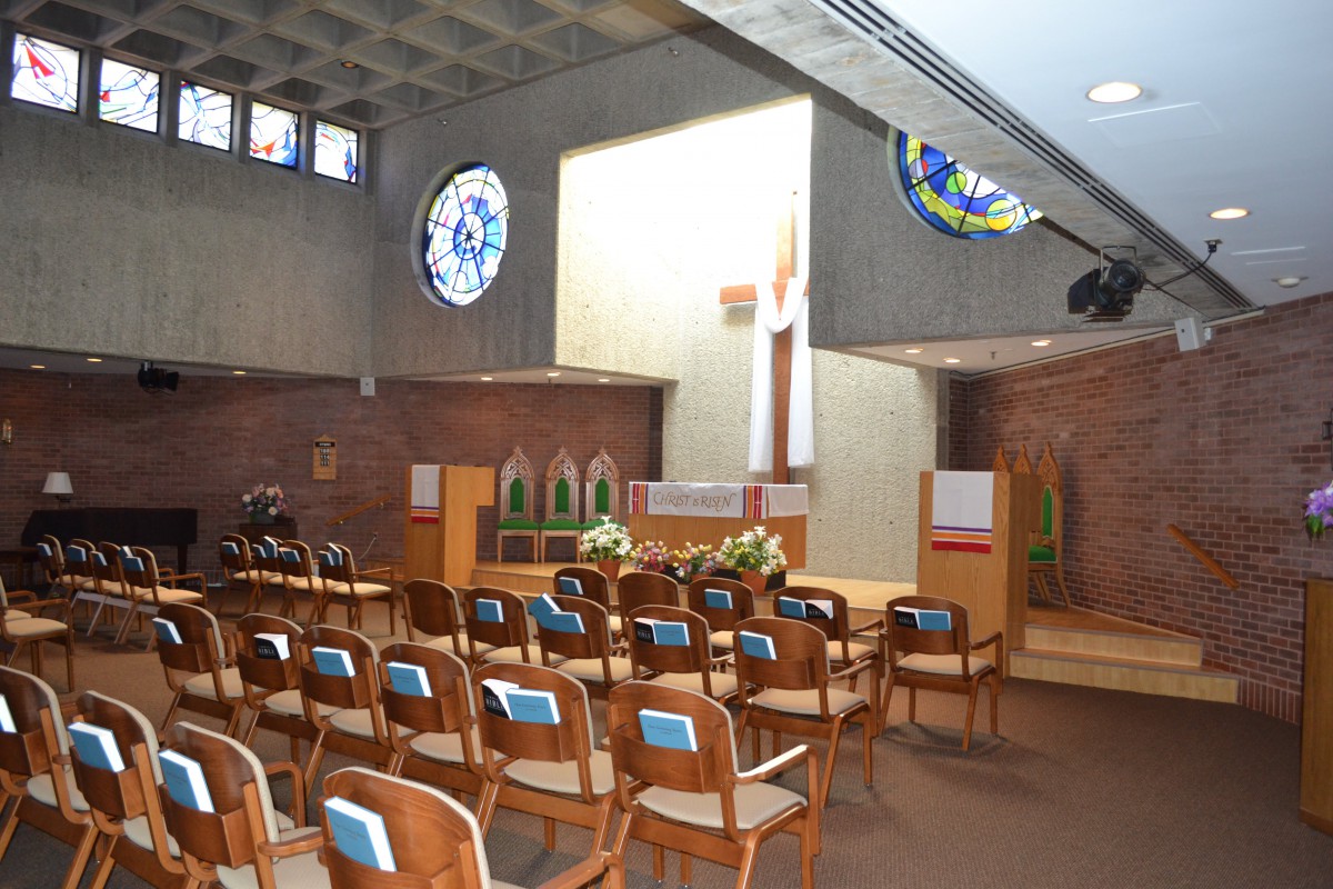 Interior of a church with pews and stained glass windows.