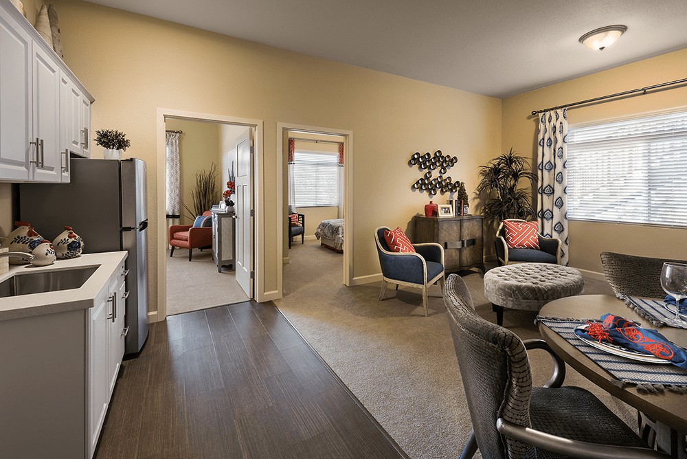 A modern apartment interior with an open layout featuring a living room and dining area.