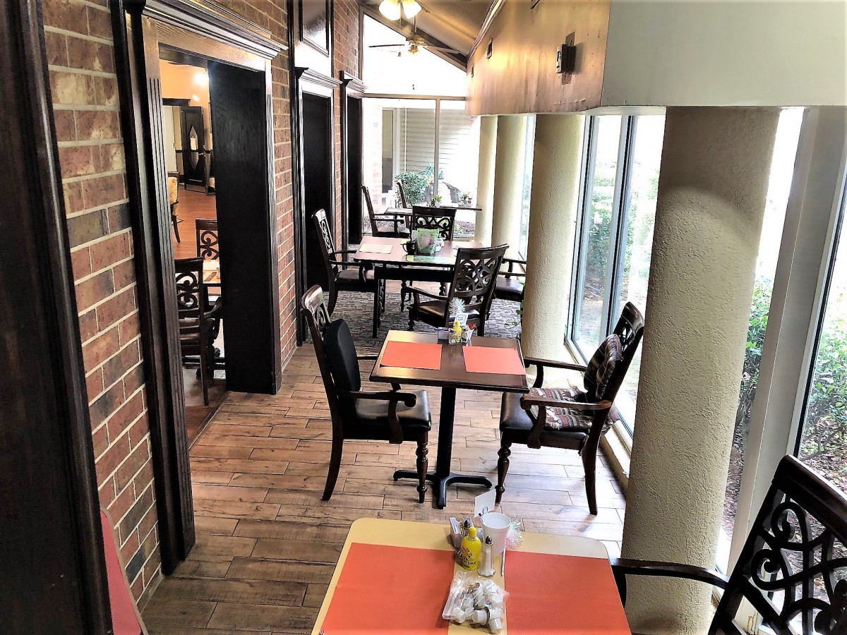 A cozy indoor dining area with natural light streaming through large windows.