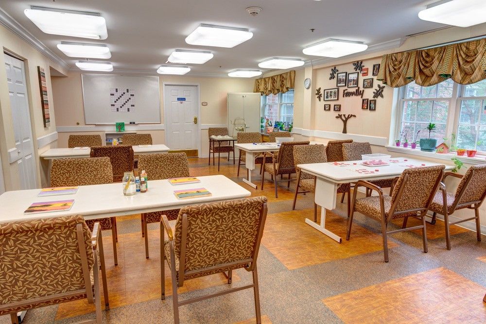 A cozy dining area with multiple tables and chairs, featuring wall decorations and warm lighting.