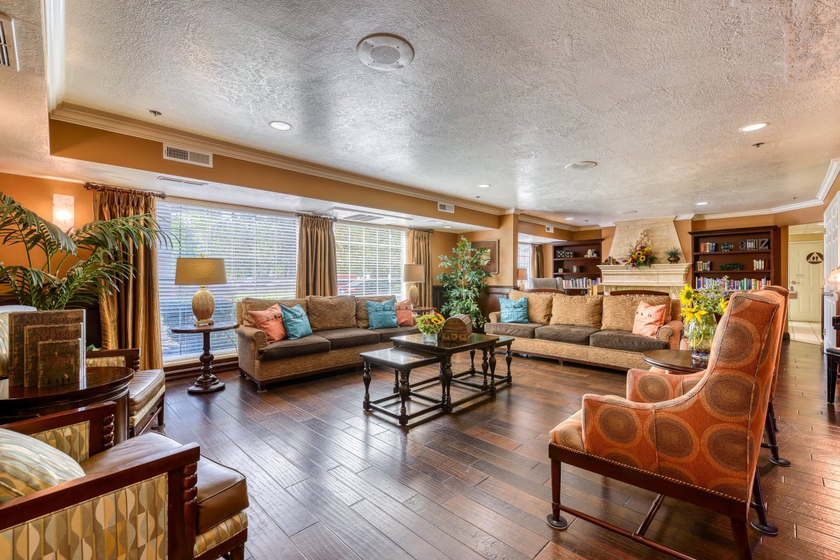 A spacious and well-lit living room featuring comfortable sofas, a central coffee table, and tasteful decor.