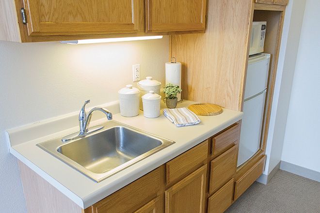 A clean kitchen with wooden cabinets and a stainless steel sink.