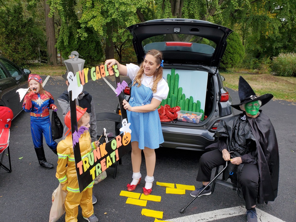 A family dressed in Wizard of Oz costumes participates in a trunk-or-treat event.