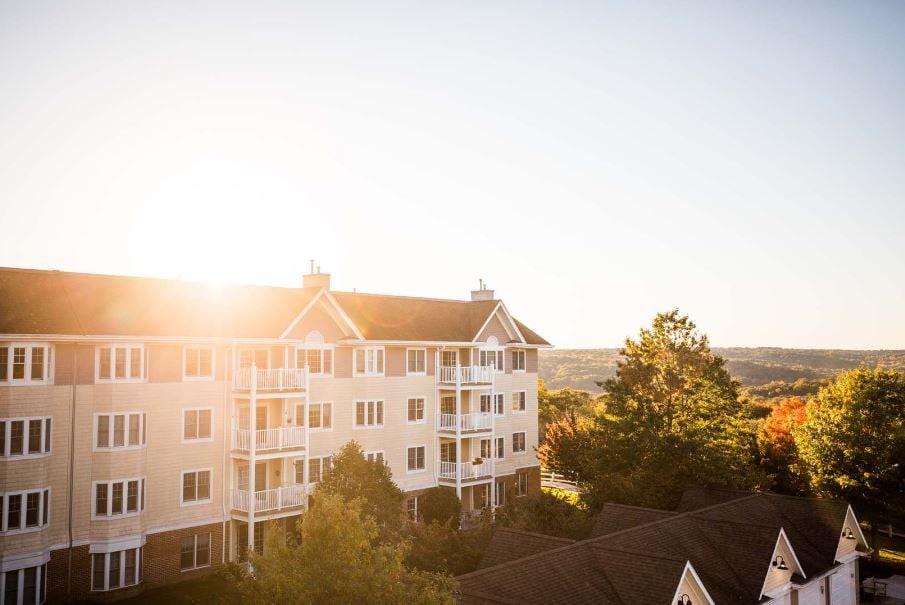 A scenic view of an apartment building basking in the warm glow of a sunset.