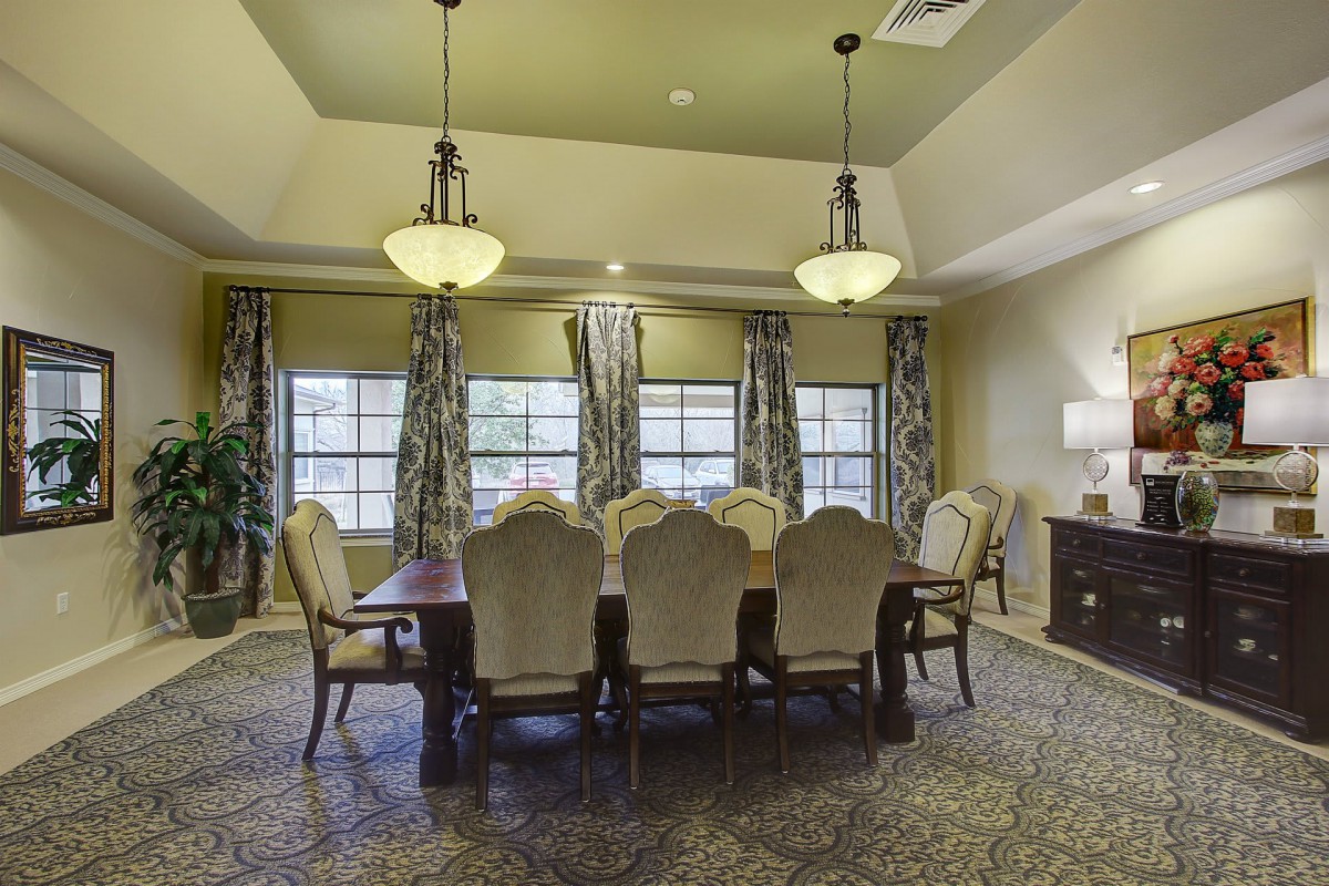 Spacious dining room with an elegant table setting and decorative lighting.