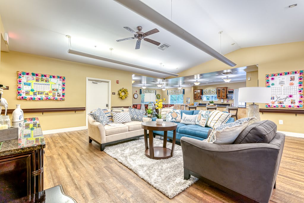 A spacious and well-decorated living room with comfortable sofas, wooden flooring, and ample lighting.