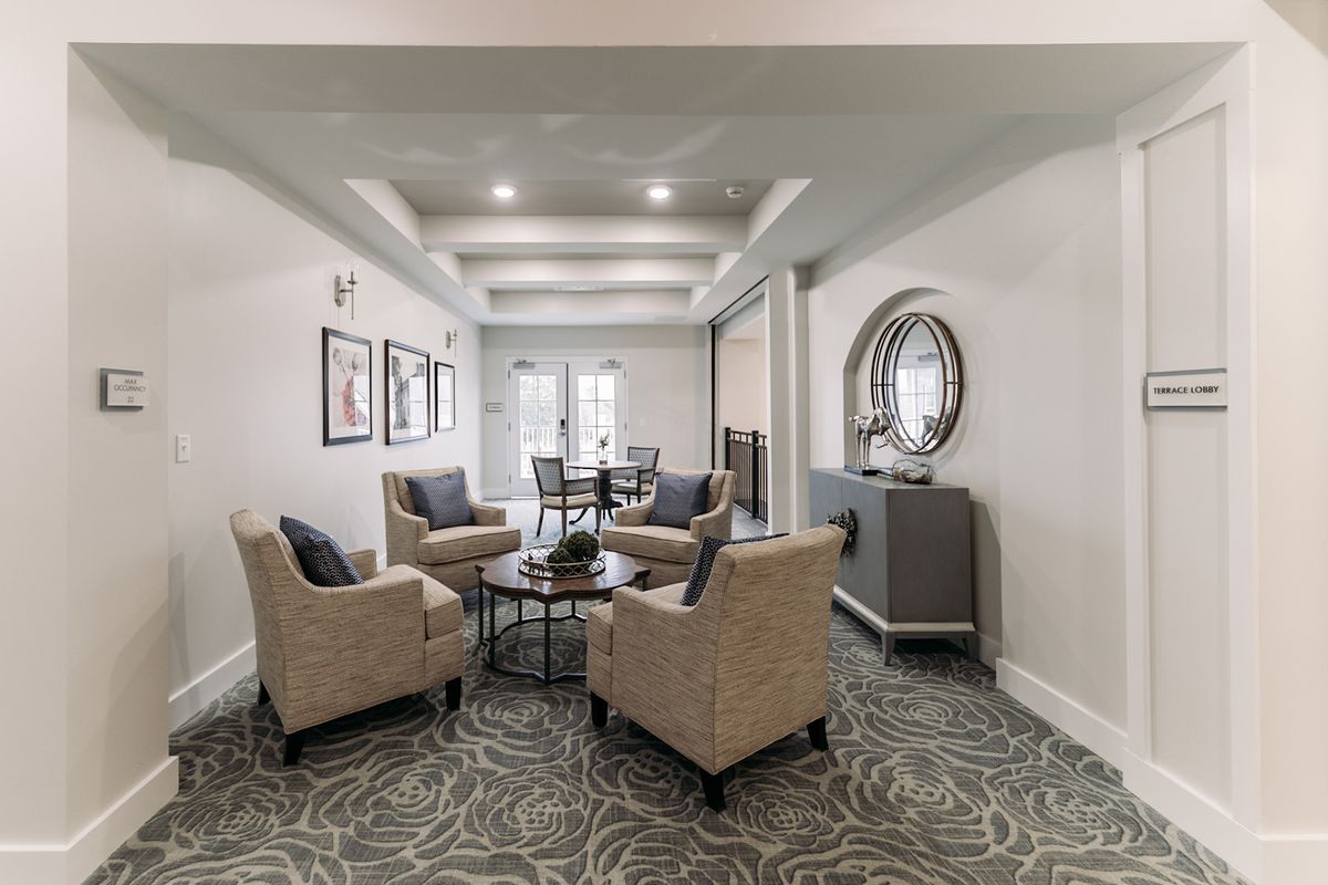 A modern living room with comfortable seating, decorative artwork, and a stylish mirror.