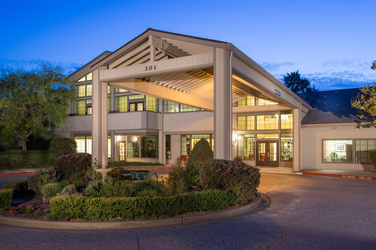 A well-lit hotel entrance with modern architecture during the evening.