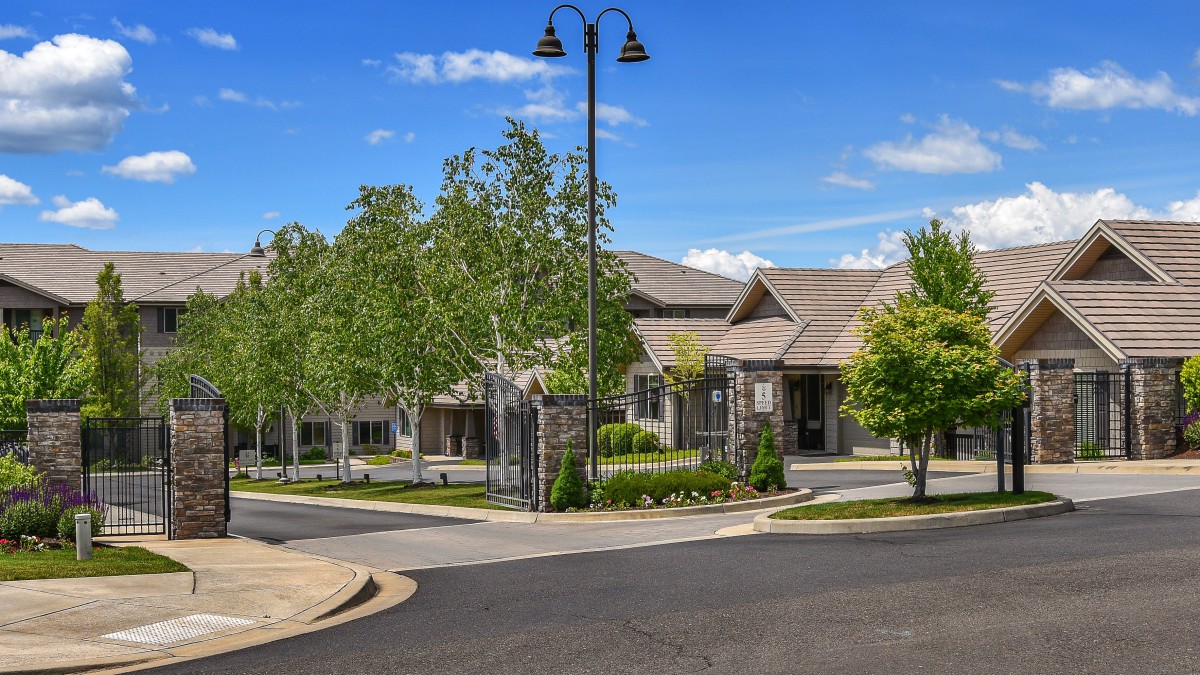 A residential building surrounded by trees on a sunny day.
