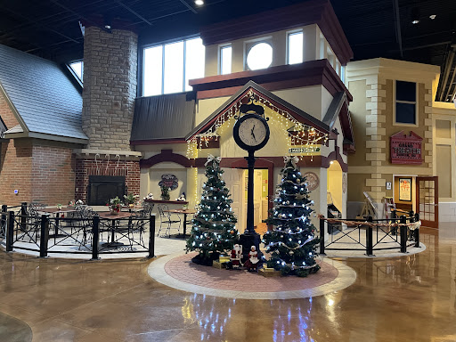 A beautifully decorated lobby featuring a large clock and festive Christmas trees.