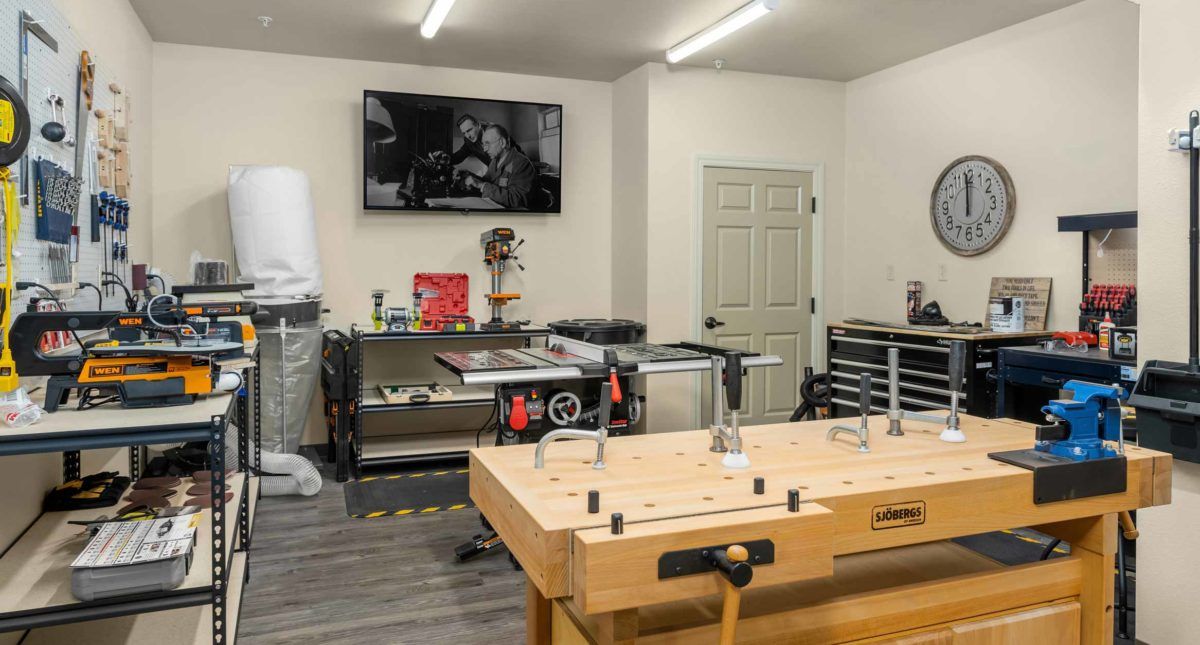 A well-equipped woodworking workshop with a large workbench and tools.