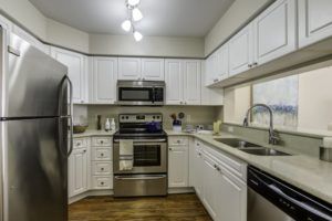 A modern kitchen with white cabinets and stainless steel appliances.
