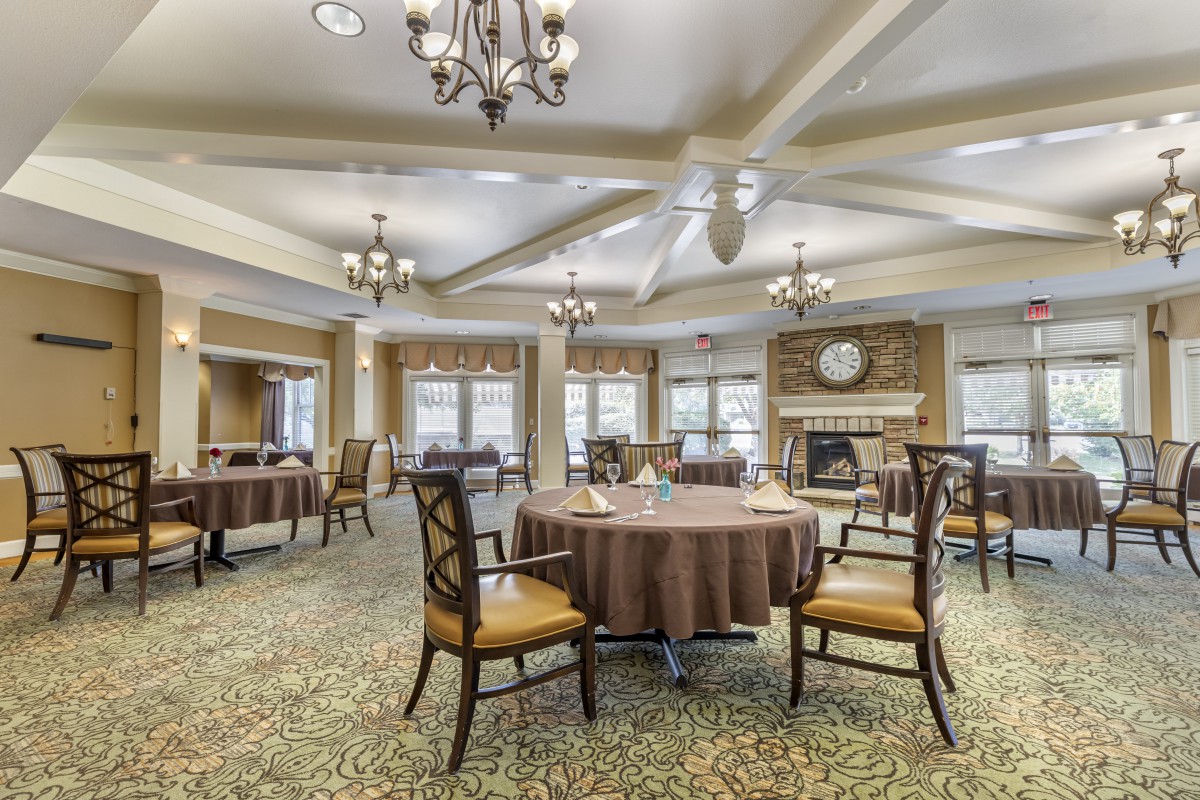 Elegant dining area with round tables and chandeliers.