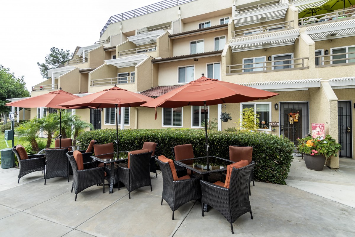 Outdoor patio area with comfortable seating and umbrellas at a modern building.