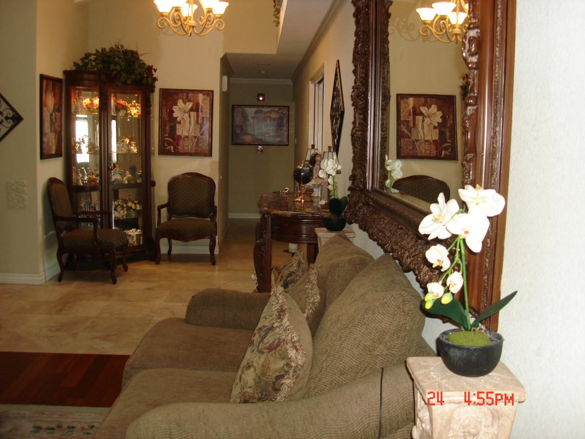 A cozy living room with a sofa, decorative mirror, and plants.