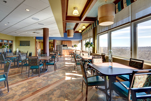 A spacious and modern dining area featuring large windows, comfortable seating, and a warm atmosphere.