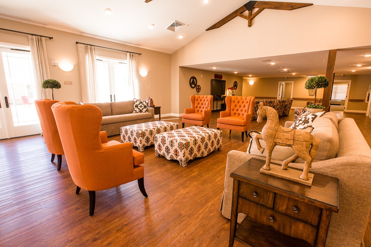 A cozy and spacious living room with modern decor and orange chairs.