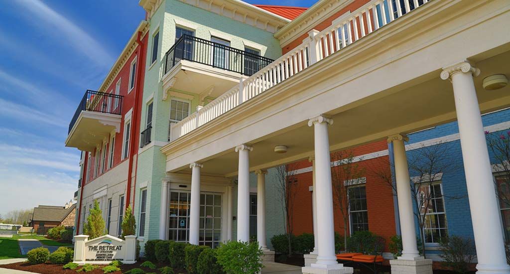 A colorful residential building with a prominent porch and columns.