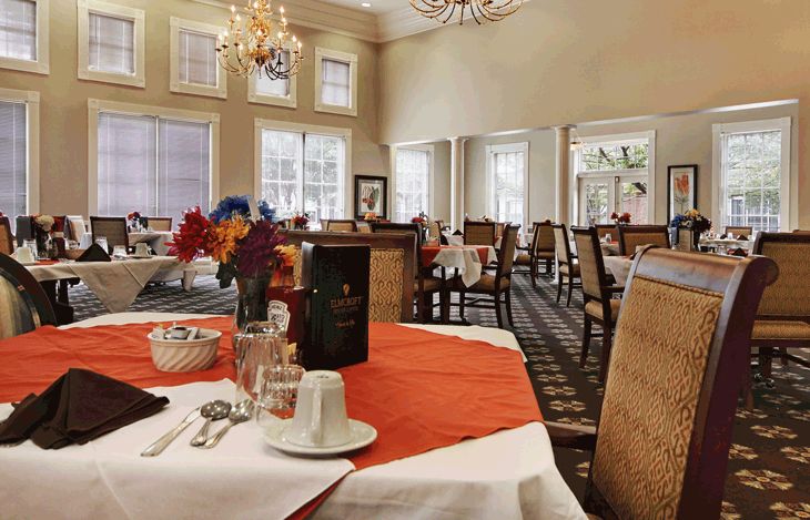 An elegant dining room with decorated tables and chandeliers.