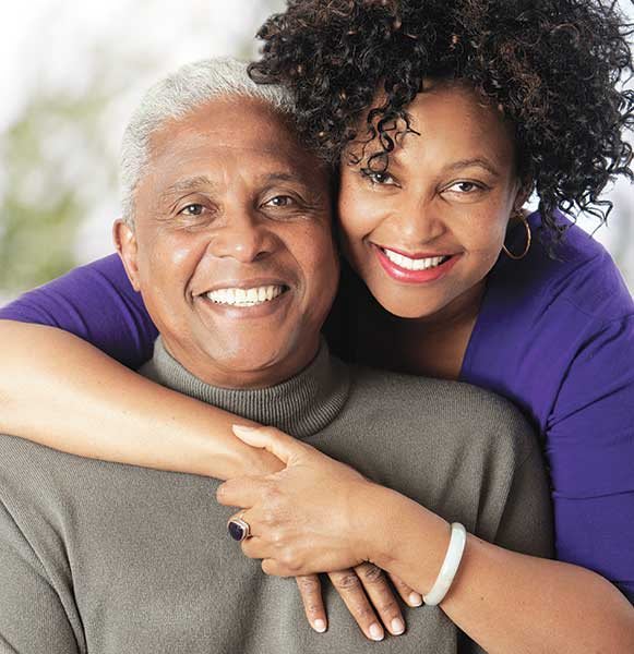 A cheerful couple embraces, sharing a joyful moment together.