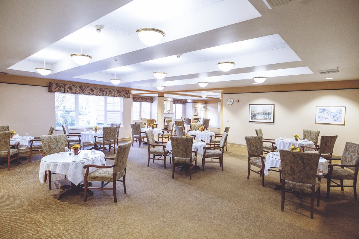 A spacious and well-lit dining area with neatly arranged tables and chairs.