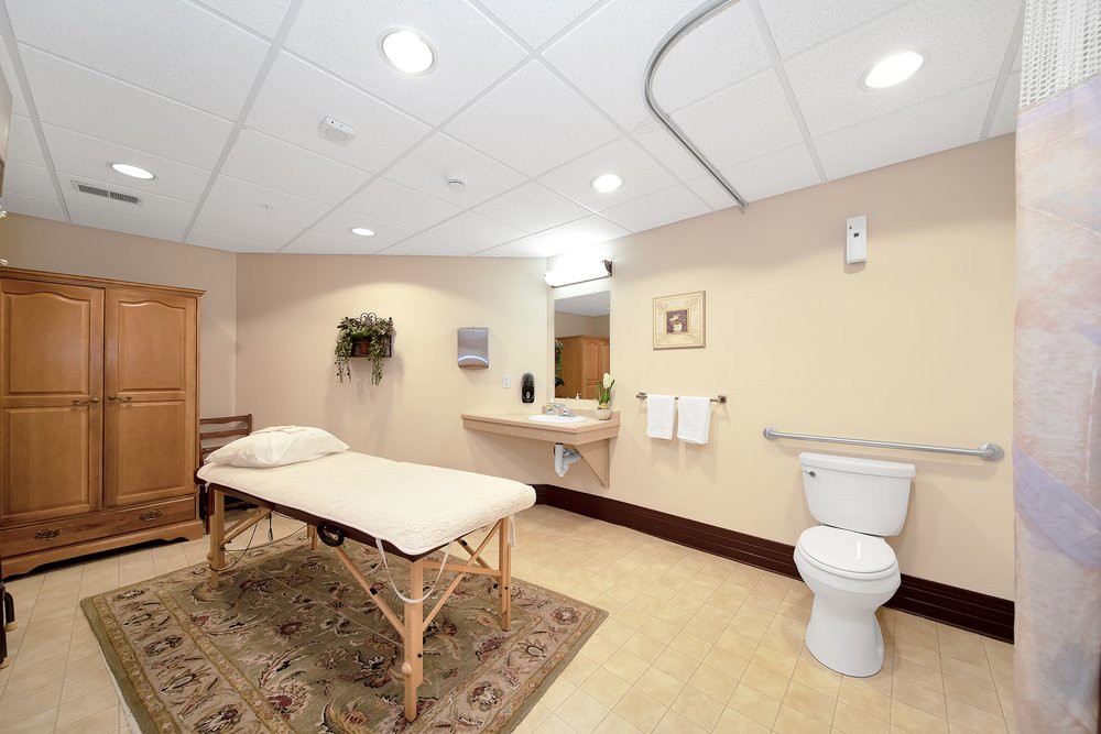 A tranquil massage room with a therapy table and restroom facilities, designed for relaxation and wellness.