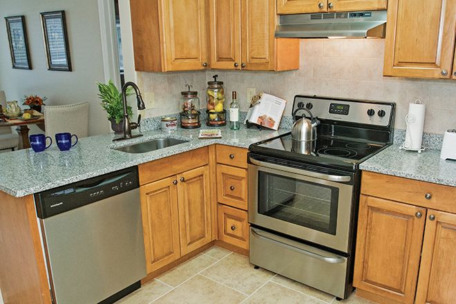 A modern kitchen with stainless steel appliances and wooden cabinetry.